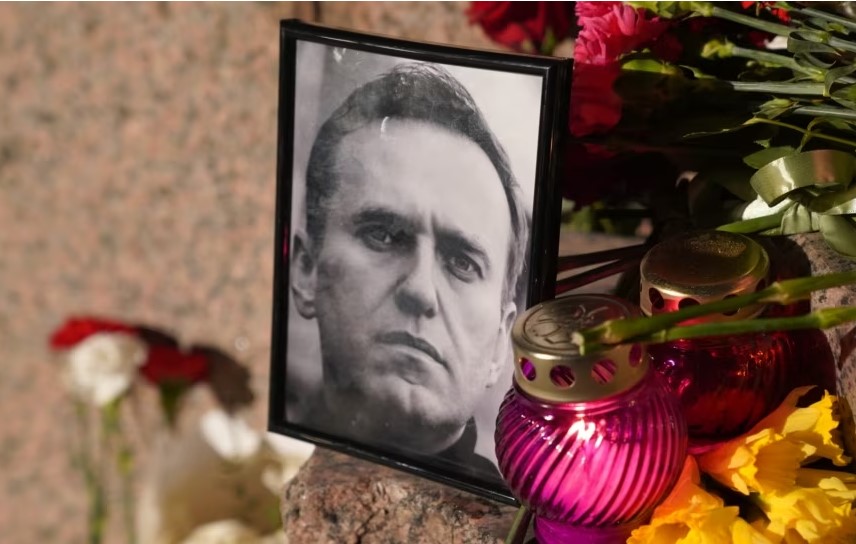 Lule të vendosura pranë një fotografie të politikanit opozitar rus, Aleksei Navalny, që vdiq në një burg të Siberisë më 16 shkurt 2024.